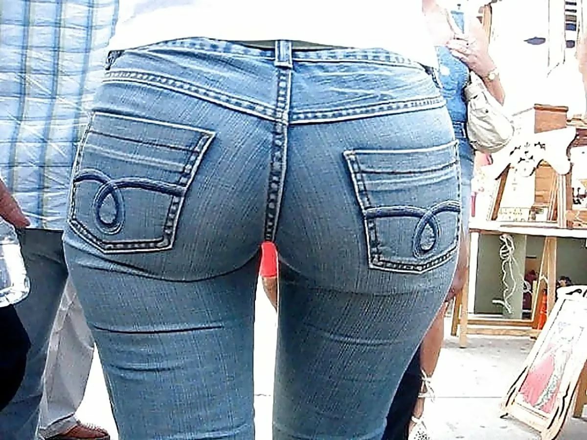 Красотка показывает обтянутую джинсами жопу и хвалится сиськами 